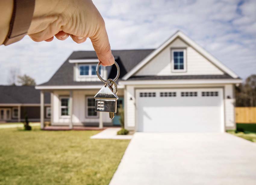 house on coins and house put on calculator. man's hand putting h